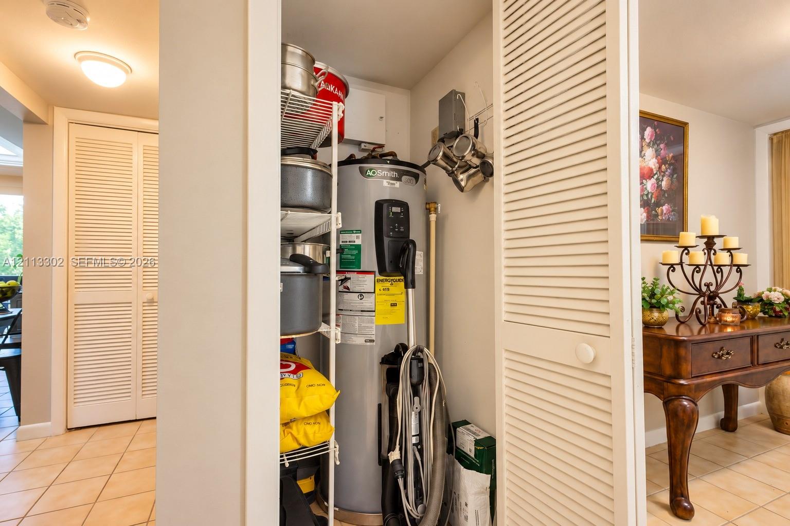 Utility closet featuring louvered bi-fold doors, white wire shelving, and a water heater