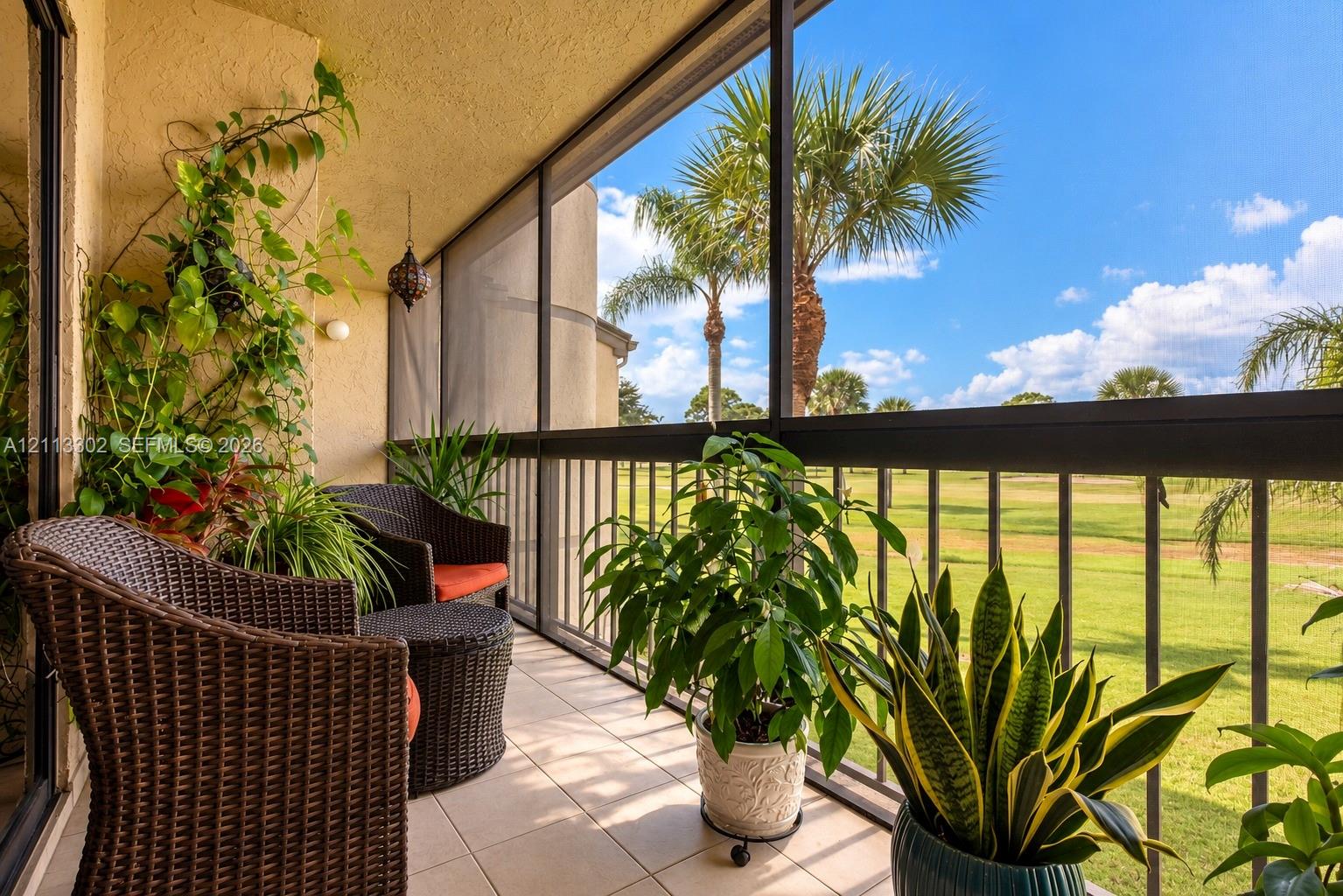 Screened-in balcony featuring tile flooring, metal railings, and stucco exterior walls