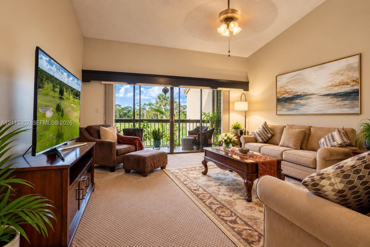 Vaulted ceilings, expansive glass sliding doors, and a ceiling fan with integrated lighting