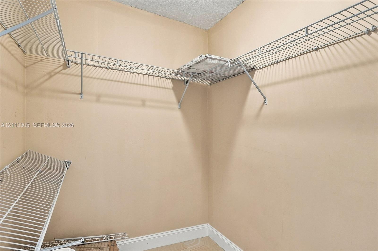 Walk-in storage space featuring multi-level white wire shelving
