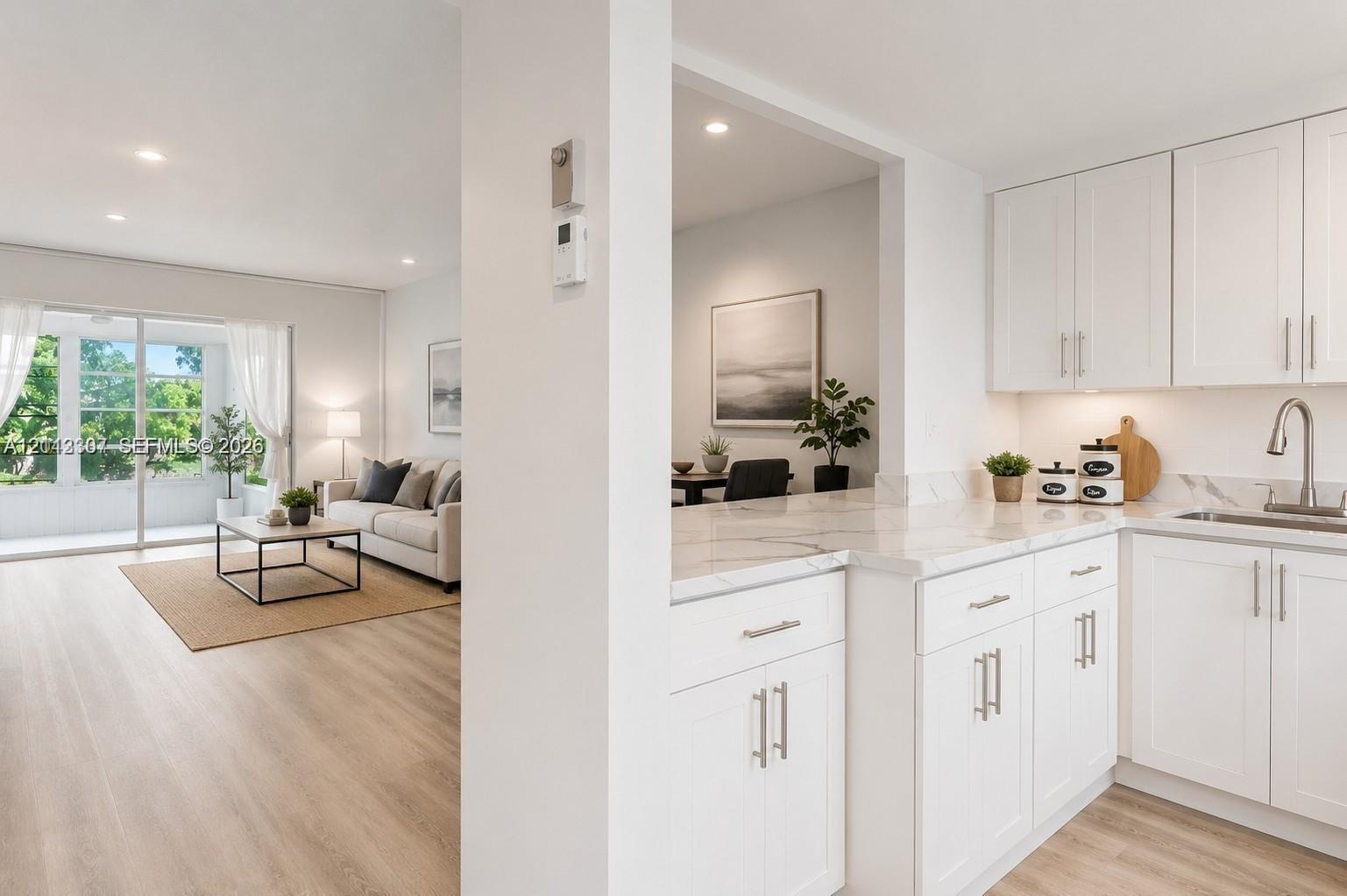 Kitchen featuring white Shaker-style cabinetry, stone-finish countertops, recessed lighting, and wood-finish flooring Kitchen featuring white Shaker-style cabinetry, stone-finish countertops, recessed lighting, and wood-finish flooring