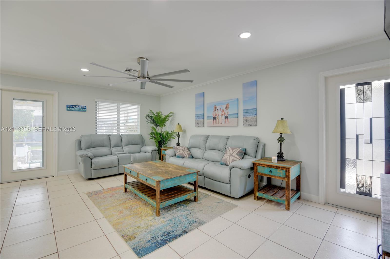 Neutral tile flooring, ceiling fan with brushed metal finish, recessed lighting, and exterior doors featuring decorative leaded glass inserts Neutral tile flooring, ceiling fan with brushed metal finish, recessed lighting, and exterior doors featuring decorative leaded glass inserts