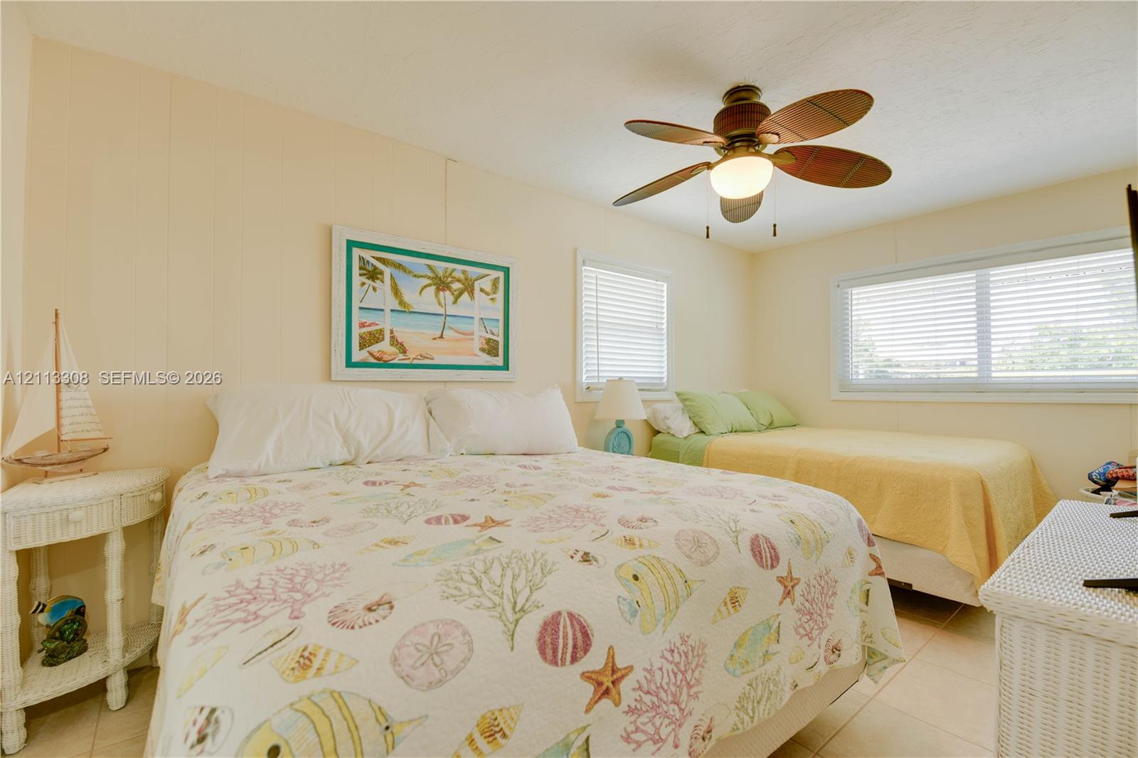 Neutral wall paneling, tile flooring, and a ceiling fan with integrated lighting Neutral wall paneling, tile flooring, and a ceiling fan with integrated lighting