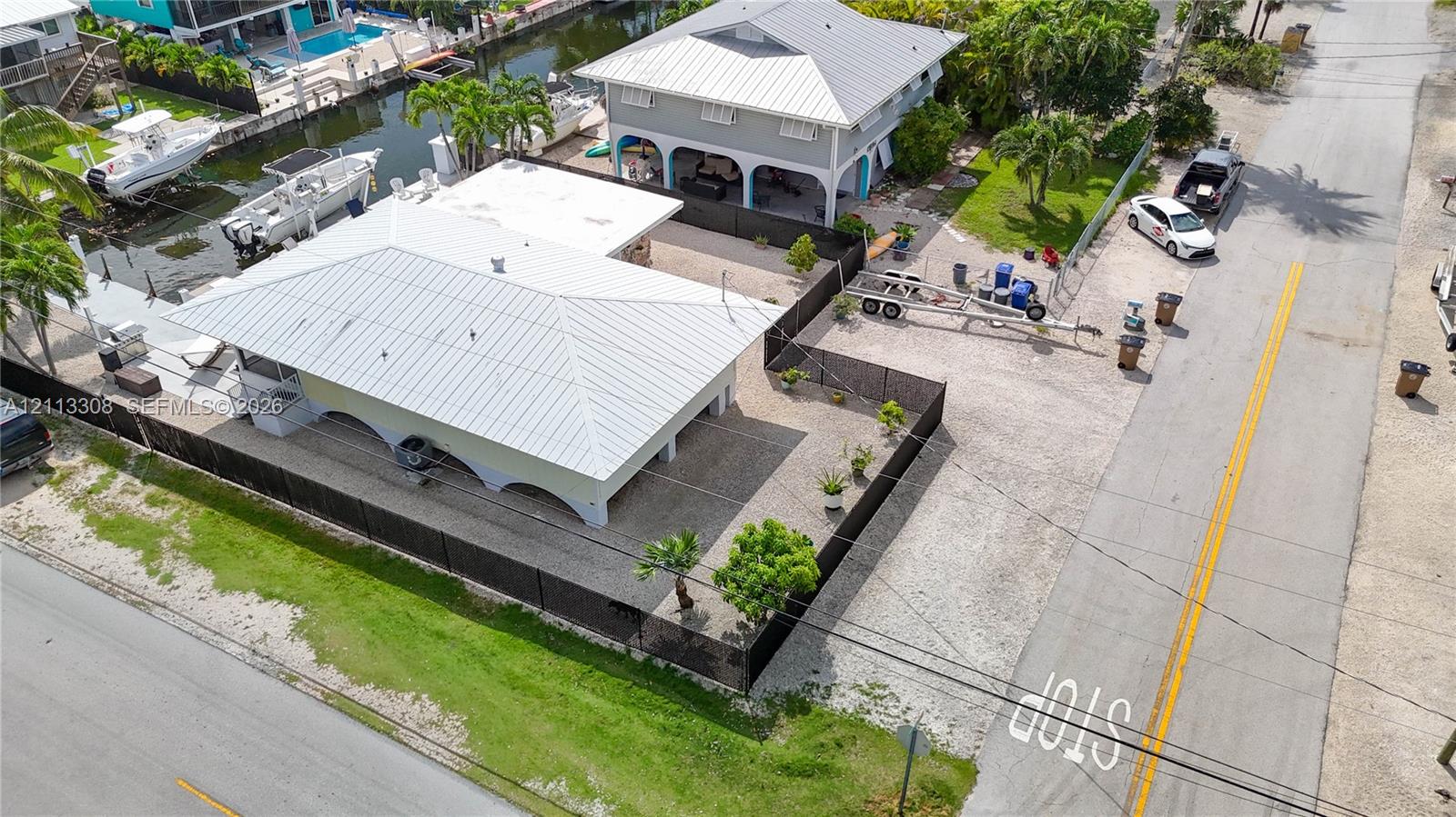 Waterfront property featuring a metal roof, concrete piling construction, and a private dock