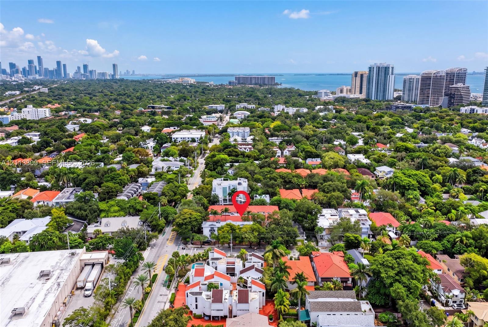 Aerial perspective of the property featuring a dense canopy of mature trees and proximity to the coastline and urban skyline