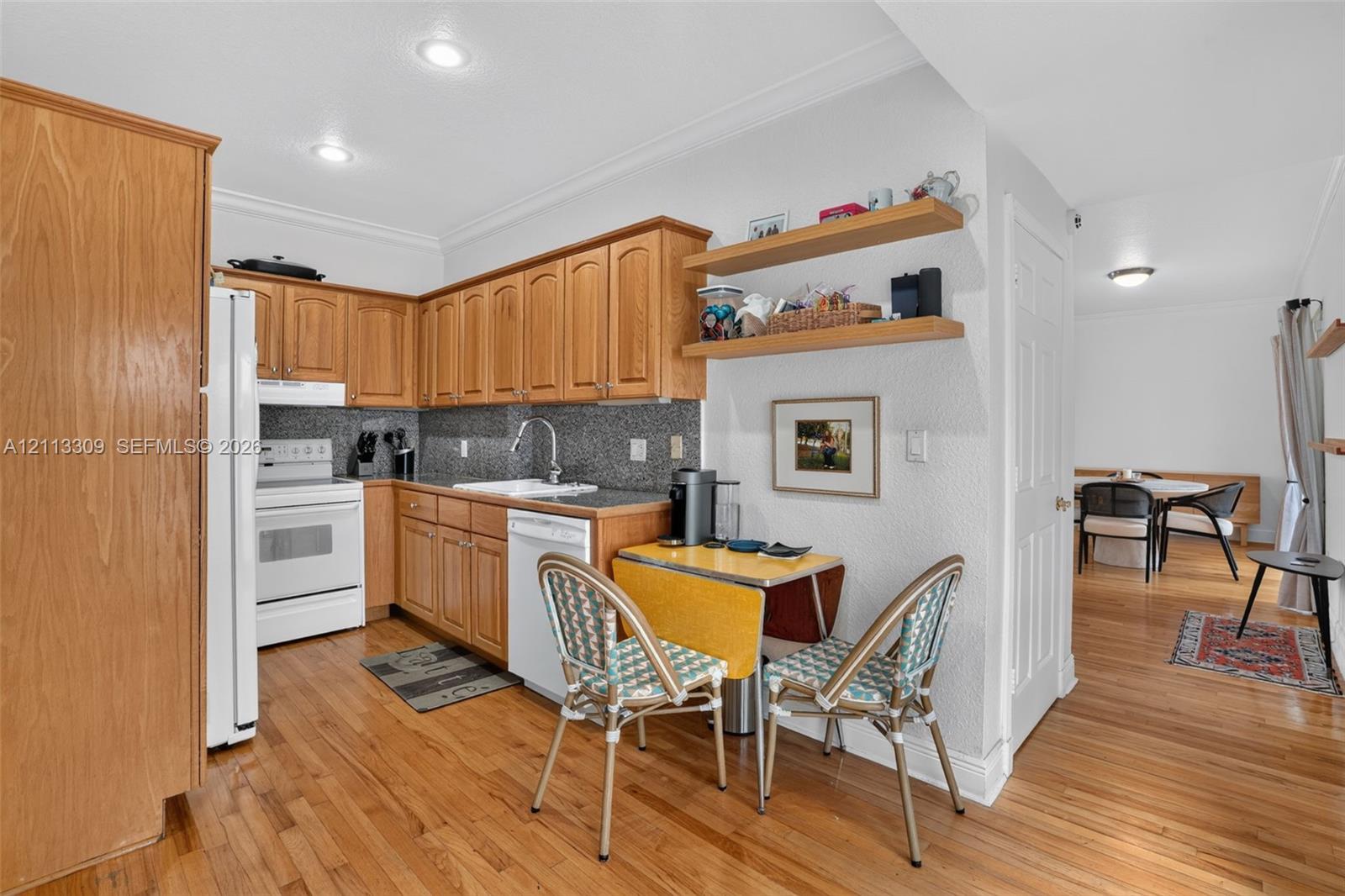 Kitchen featuring wood cabinetry, natural wood-finish flooring, recessed lighting, stone-textured backsplash, and built-in open shelving