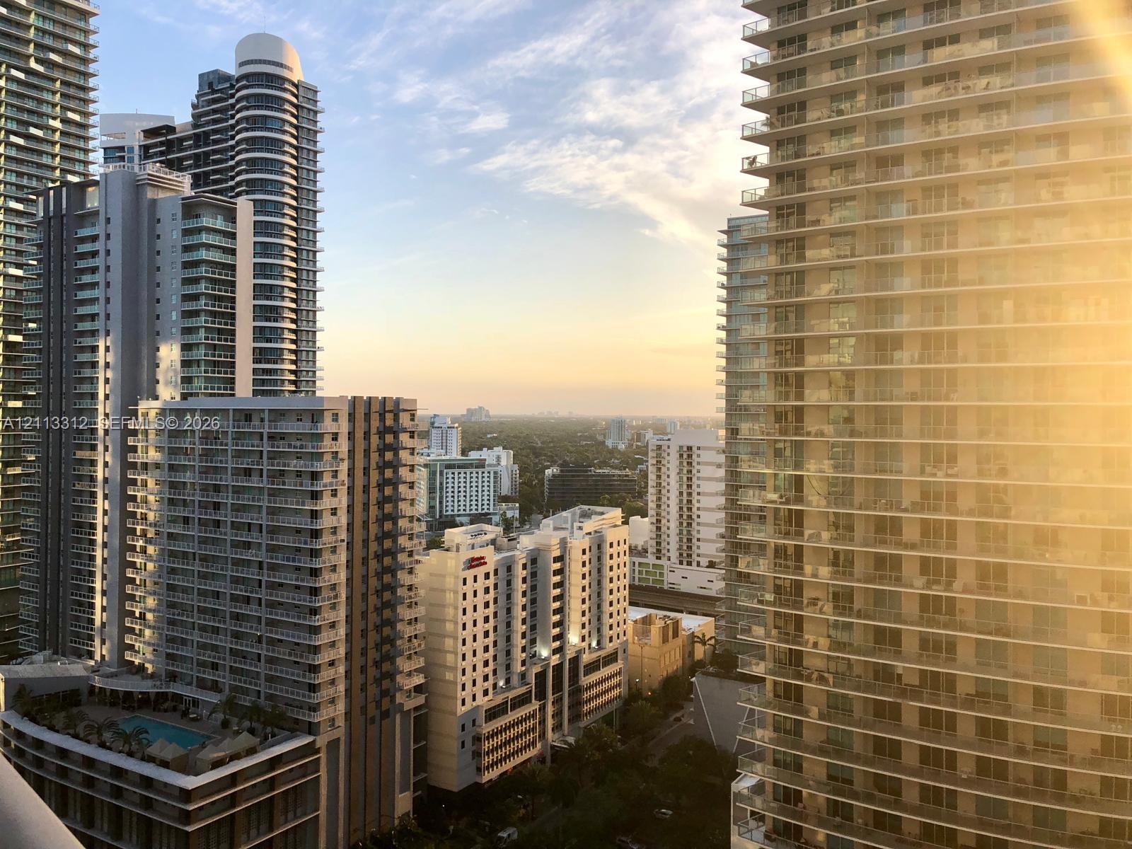 High-rise urban landscape featuring glass balcony railings, floor-to-ceiling windows, tiered building architecture, and an elevated outdoor swimming pool High-rise urban landscape featuring glass balcony railings, floor-to-ceiling windows, tiered building architecture, and an elevated outdoor swimming pool
