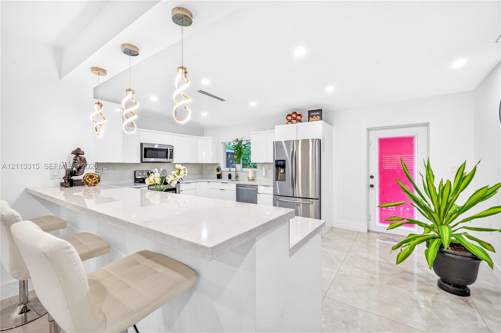 Kitchen featuring stone-finish countertops, a breakfast bar, stainless steel appliances, white cabinetry, and recessed lighting