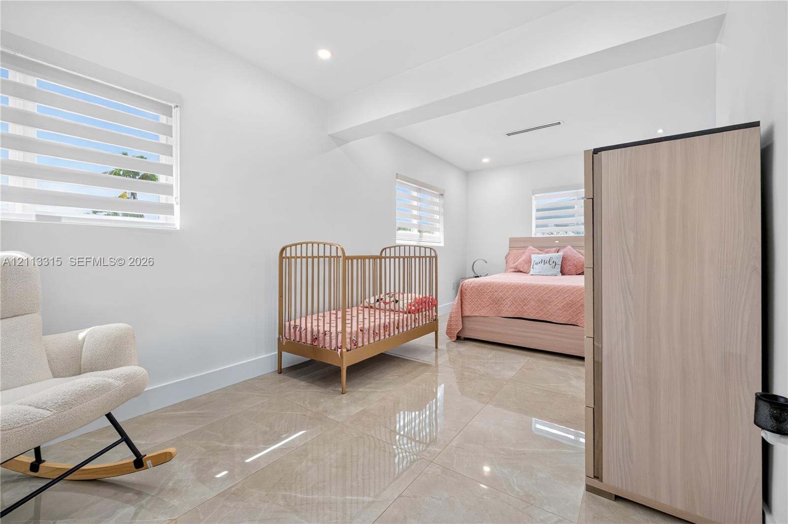Large-format tile flooring, recessed ceiling lighting, and windows featuring dual-layer shade systems