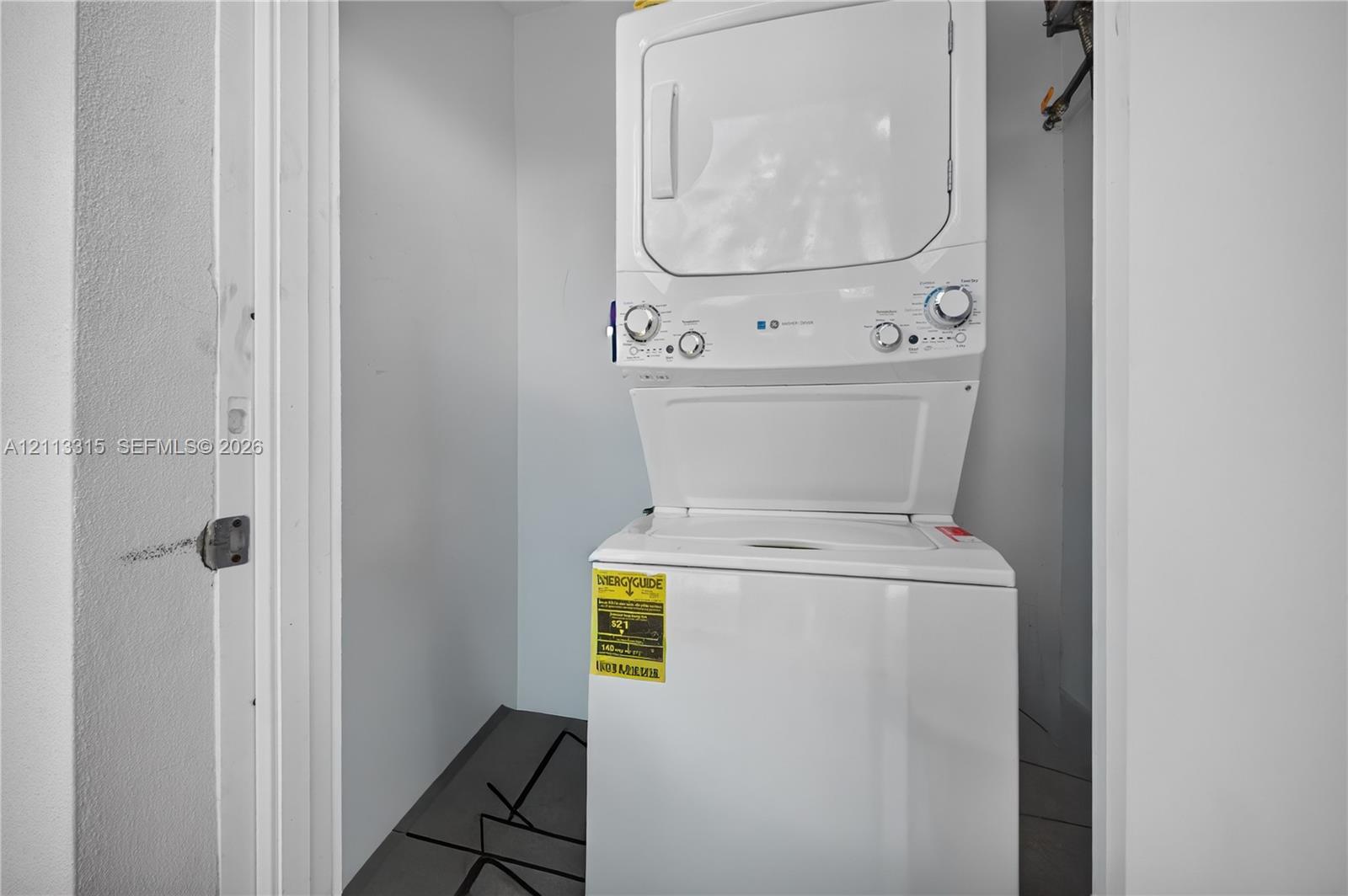 Built-in stacked laundry unit with white finish and neutral wall enclosure