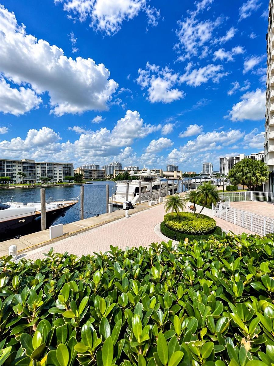 Waterfront property featuring a paved bulkhead, deep-water dockage, palm landscaping, and integrated perimeter fencing