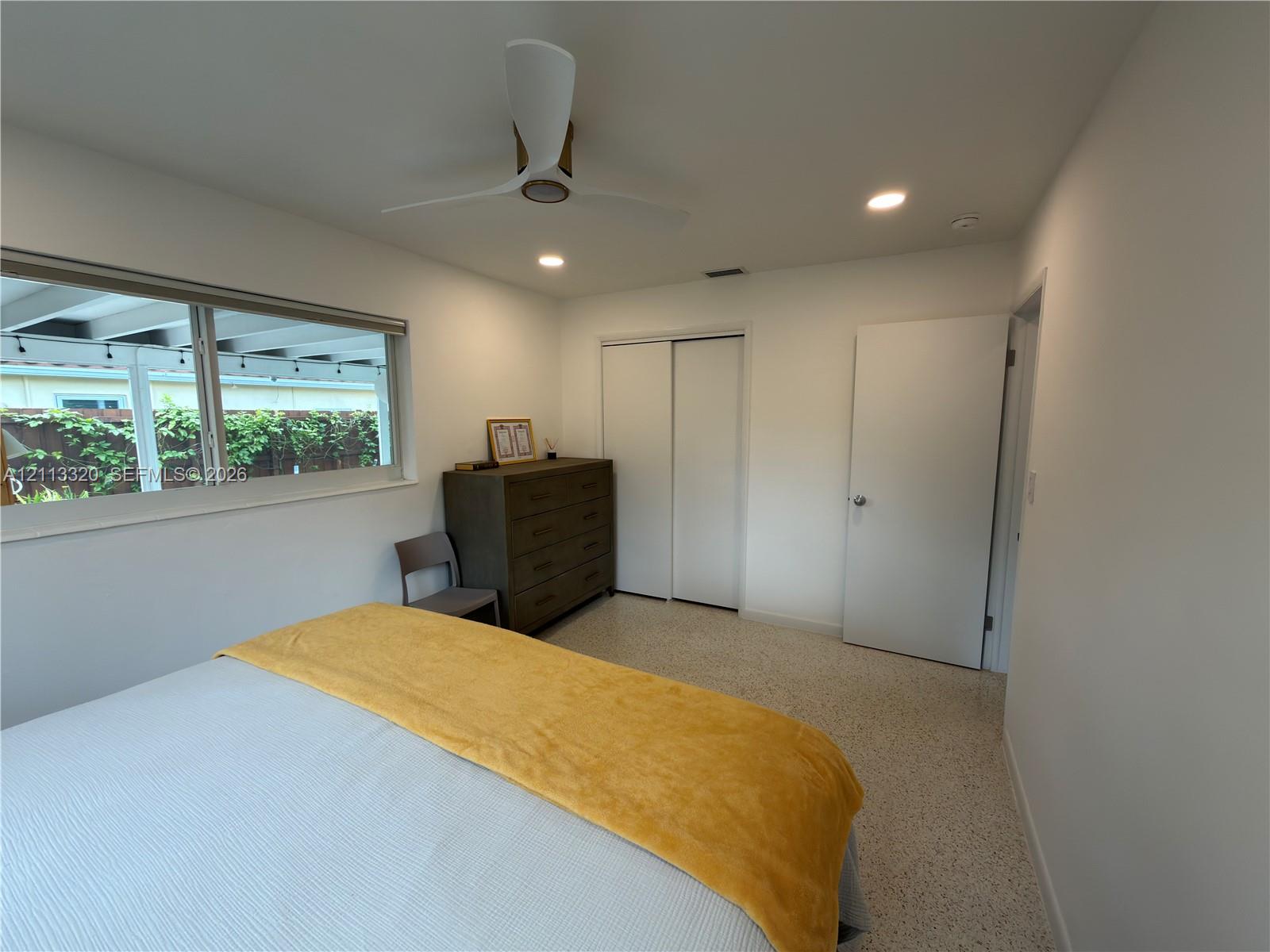 Interior space featuring recessed lighting, a three-blade ceiling fan, terrazzo flooring, and a sliding-door closet