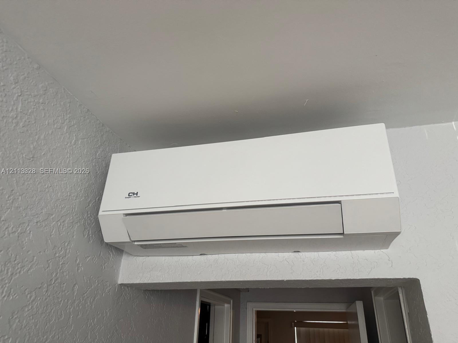 Wall-mounted ductless HVAC unit featuring a white finish and minimalist casing