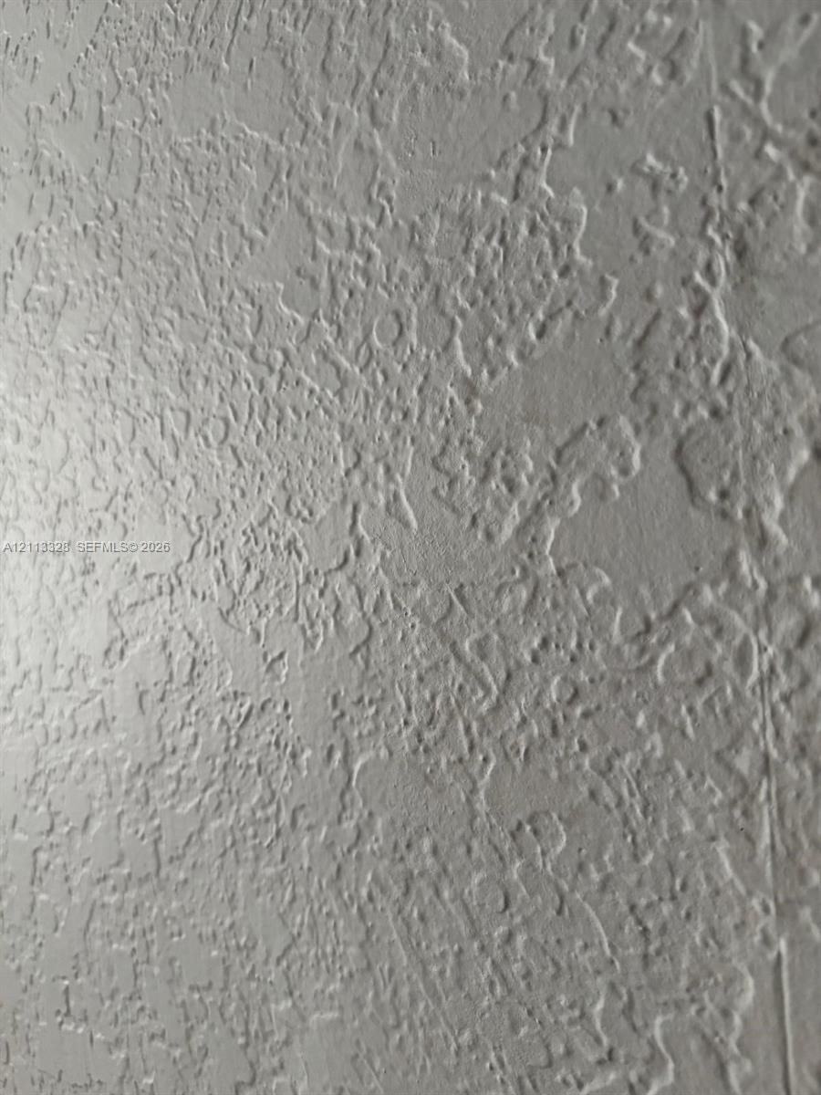 Interior wall featuring a neutral, monochromatic hand-applied knockdown texture finish