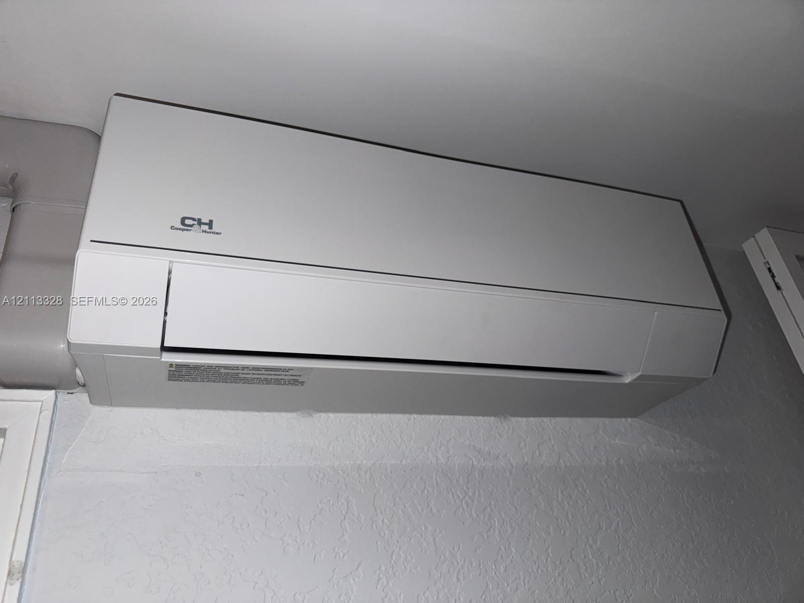 Wall-mounted ductless mini-split climate control unit with a matte white finish