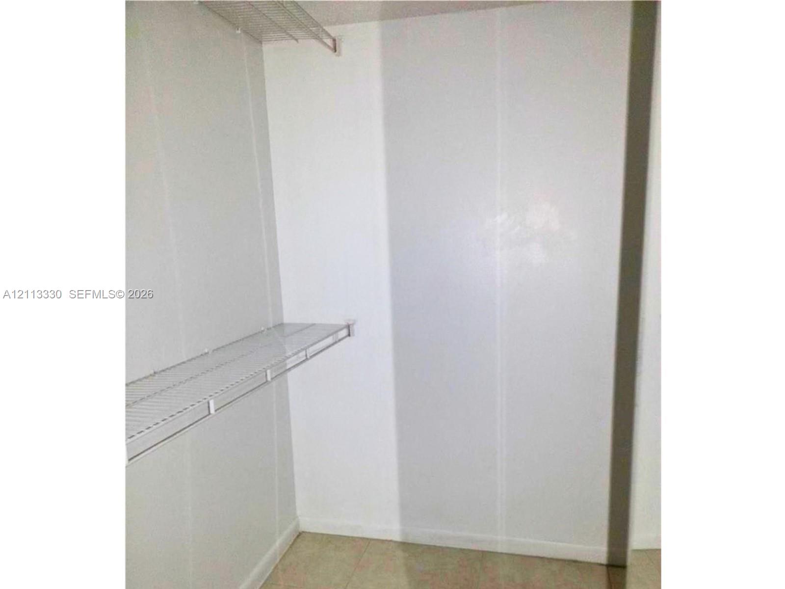 Storage space featuring white walls and two levels of wire shelving Storage space featuring white walls and two levels of wire shelving