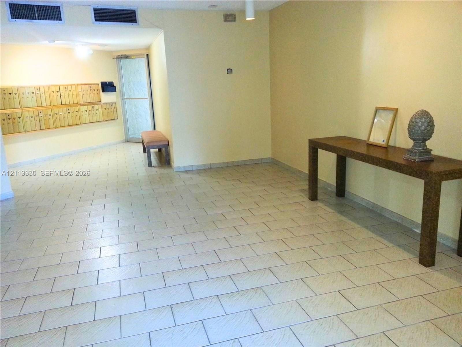 Common area featuring large-format ceramic tile flooring, recessed ceiling lighting, and integrated wall-mounted mailboxes