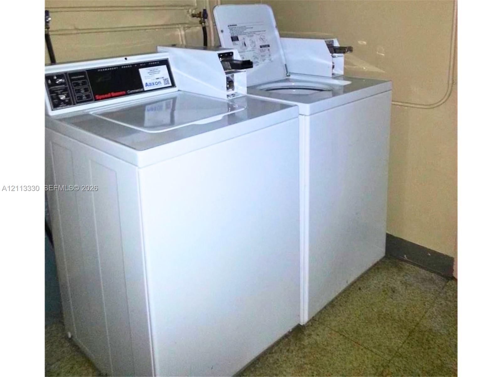 Utility area featuring white top-loading laundry appliances and solid-surface flooring