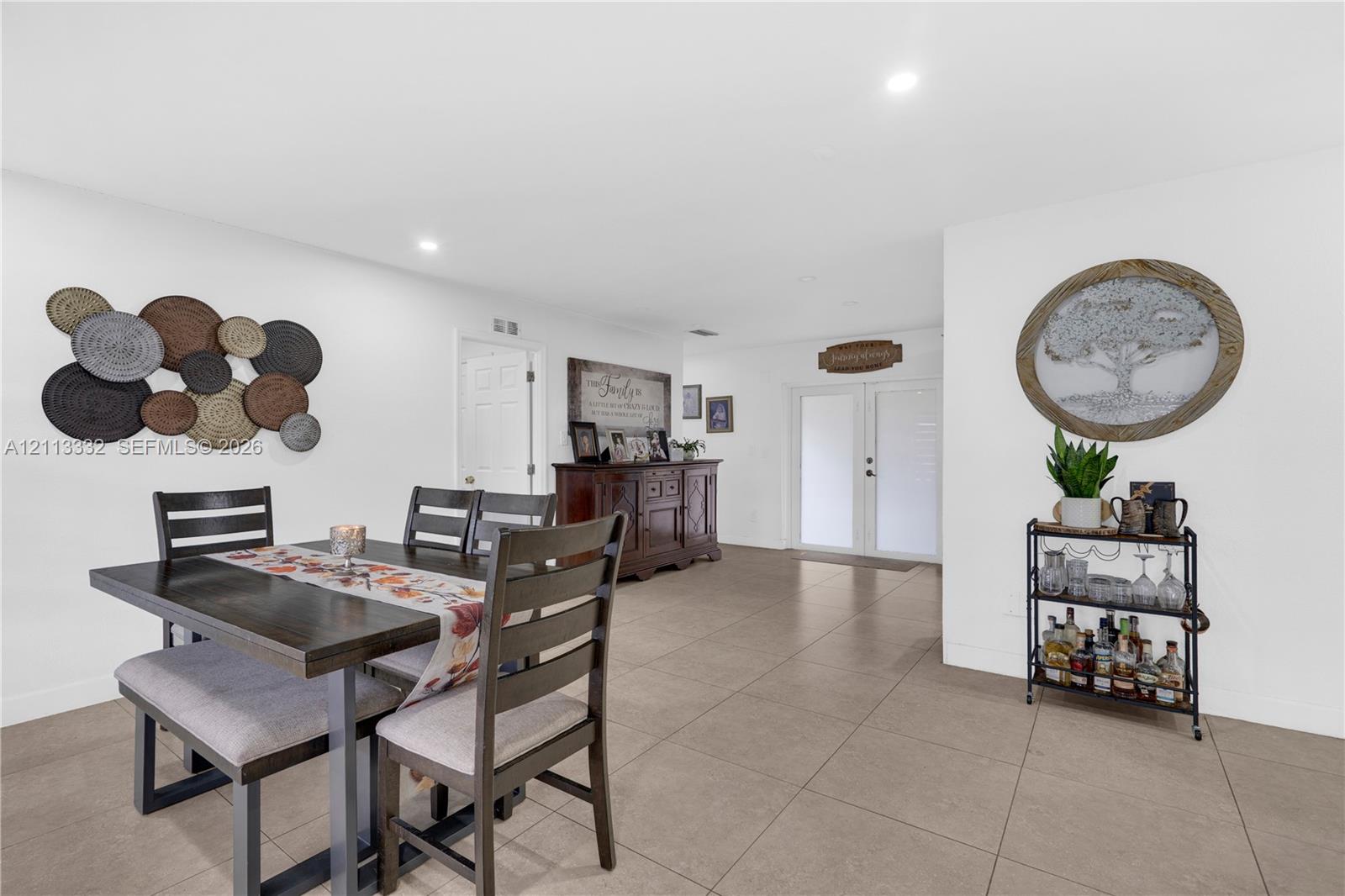 Open-concept floor plan featuring large-format tile flooring and recessed lighting