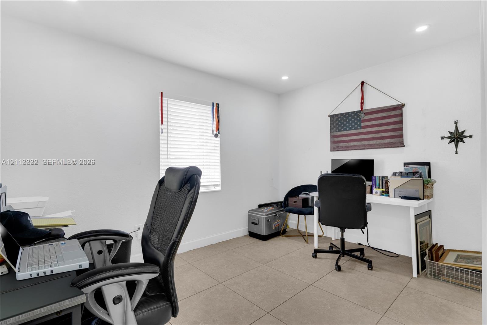 Neutral-toned tile flooring, recessed ceiling lighting, and a window with horizontal blinds