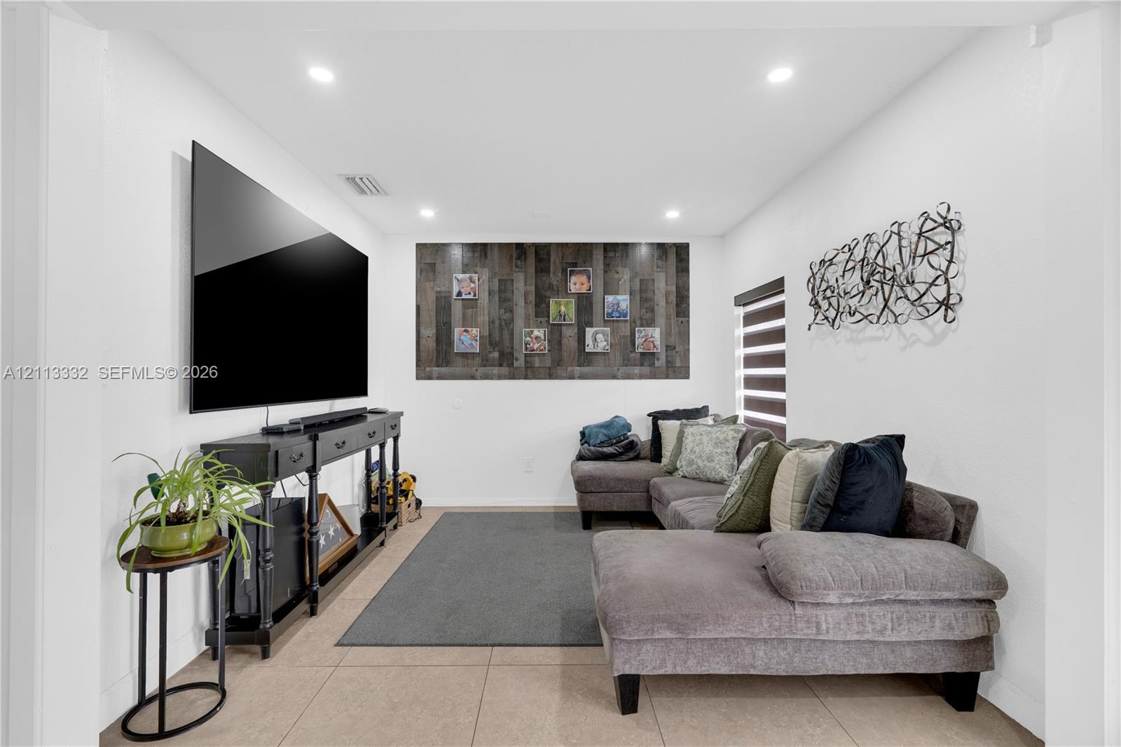 Interior space featuring large-format tile flooring, recessed ceiling lighting, and a textured wood-plank accent wall