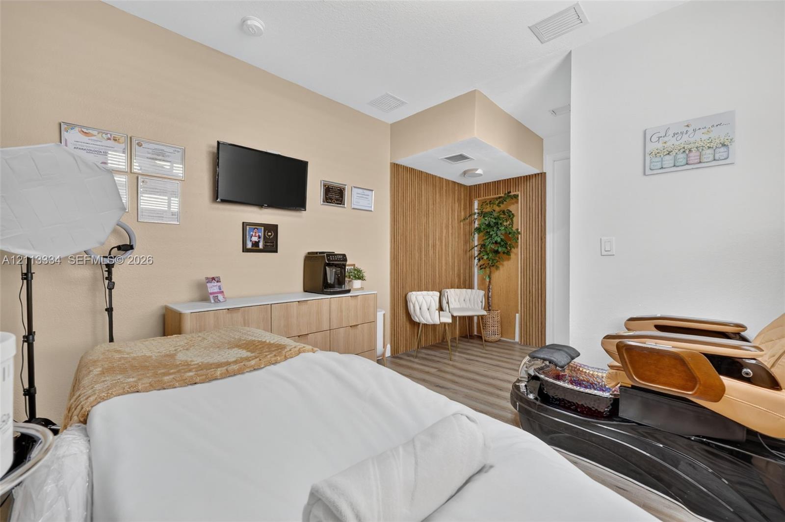 Built-in light-tone cabinetry with solid surfacing, vertical wood-panel accent wall, and wood-finish flooring