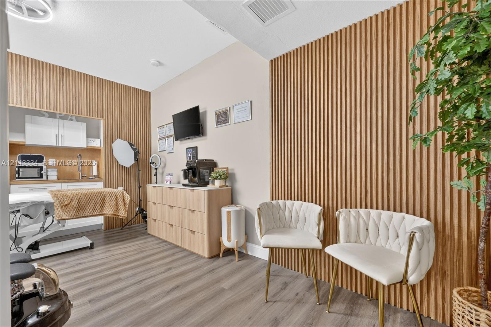 Vertical slat wood paneling on feature walls, integrated cabinetry with a built-in sink, and wood-finish flooring