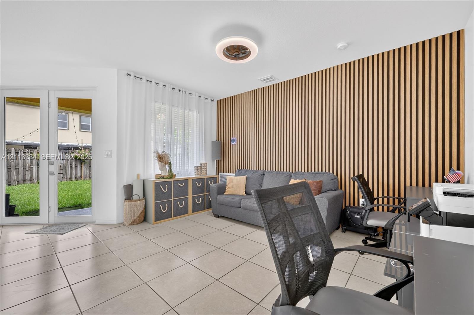 Vertical wood-slat accent wall, large format tile flooring, and glass-paneled French doors