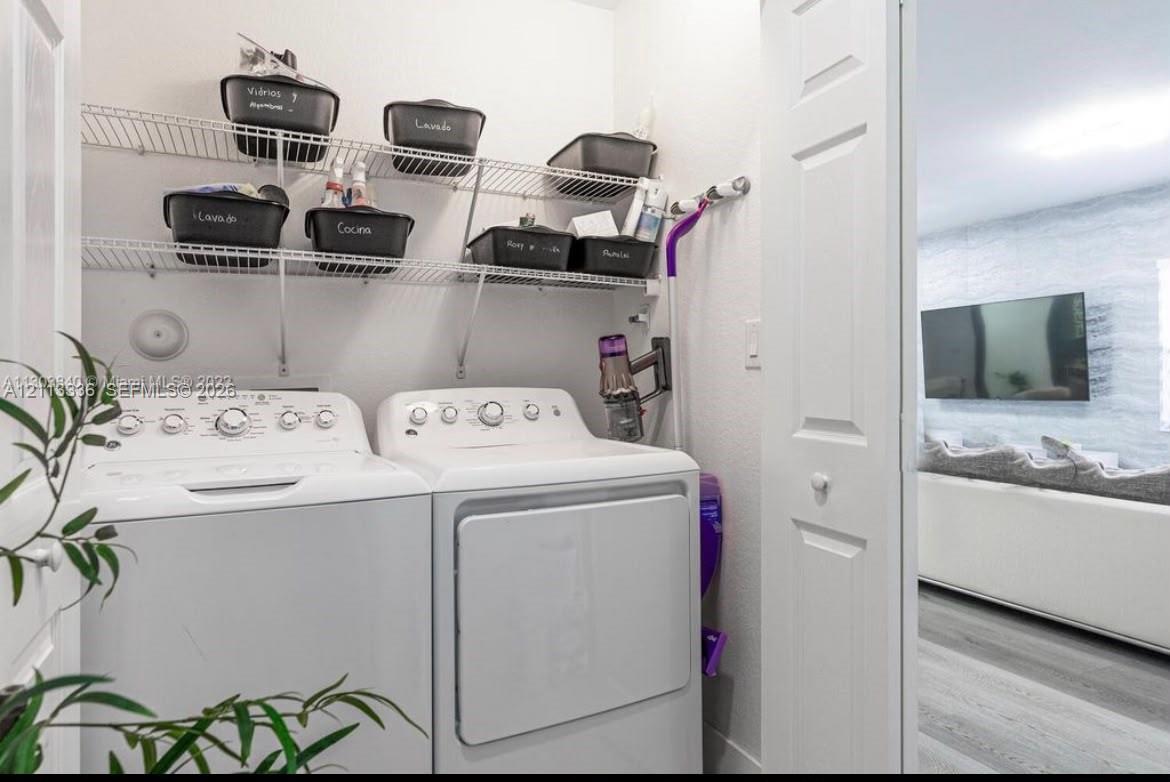 Laundry area featuring white top-loading appliances and dual-tier wire shelving