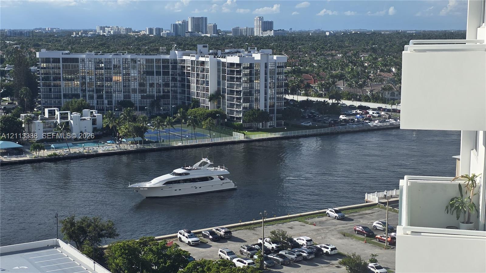 Elevated exterior balcony featuring white structural railing overlooking a waterfront waterway