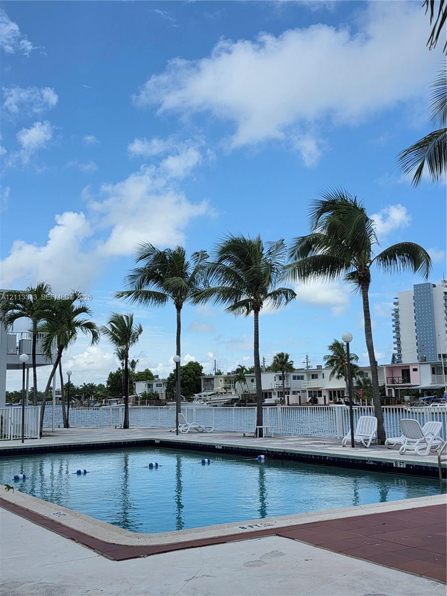 Swimming pool featuring a concrete deck against a waterfront backdrop