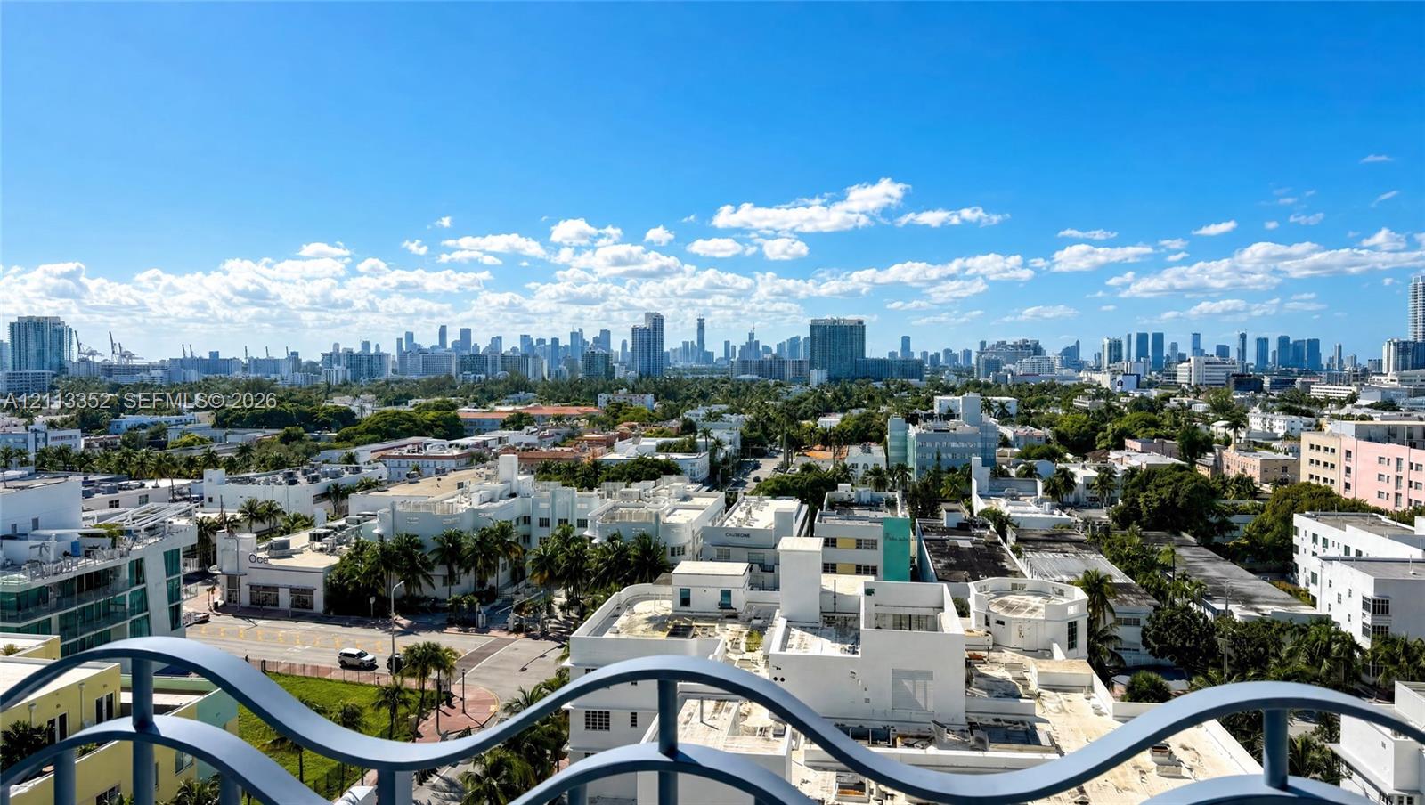 Elevated balcony featuring decorative blue metal railings with expansive skyline scenery