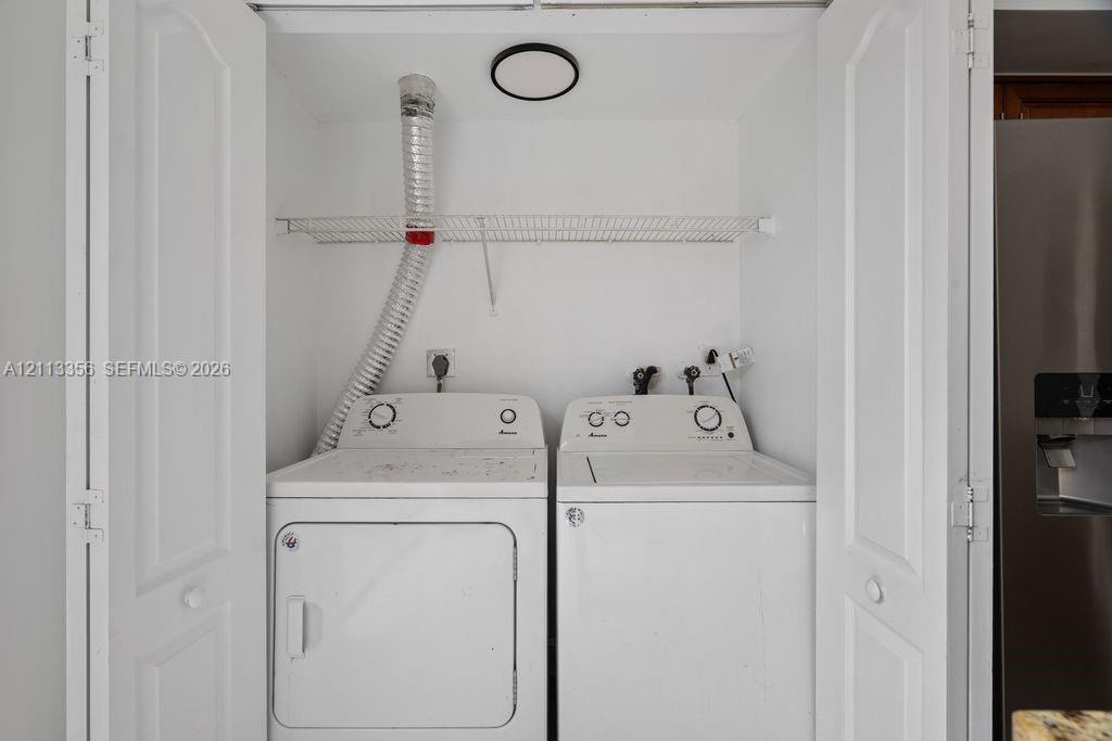 Laundry closet featuring white bifold doors, an integrated wire shelving unit, and a flush-mount circular ceiling light