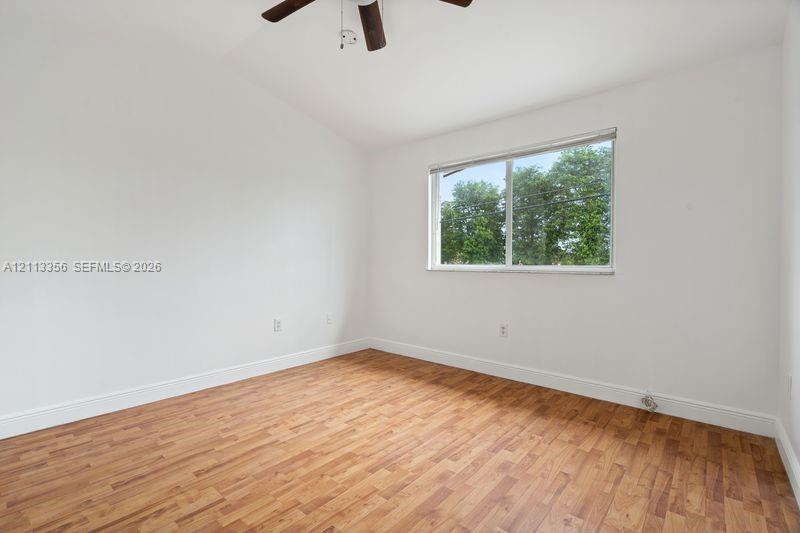 Interior room featuring vaulted ceilings, wood-finish flooring, and a ceiling fan