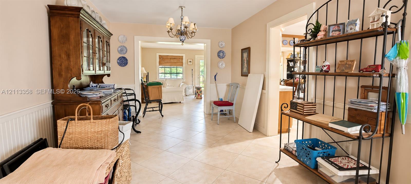 Interior space featuring tile flooring, wainscoting, and a decorative multi-arm chandelier