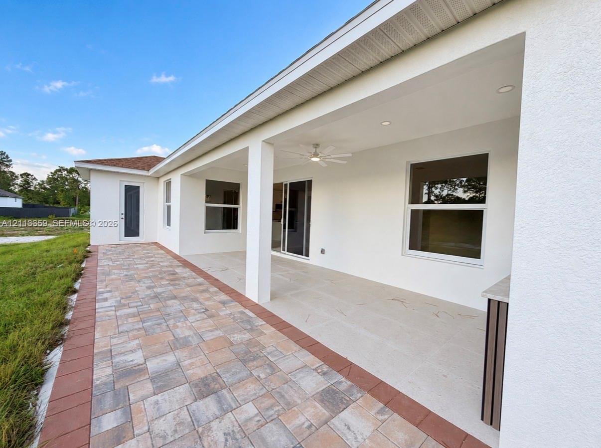 Covered patio with recessed lighting, integrated ceiling fan, paver flooring, and built-in exterior cabinet