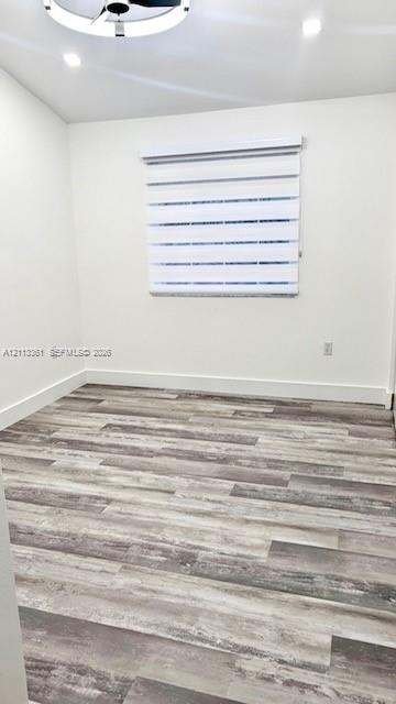 Floating wood-finish vanity with dual vessel sinks, quartz countertop, large backlit mirror, and textured wall tile