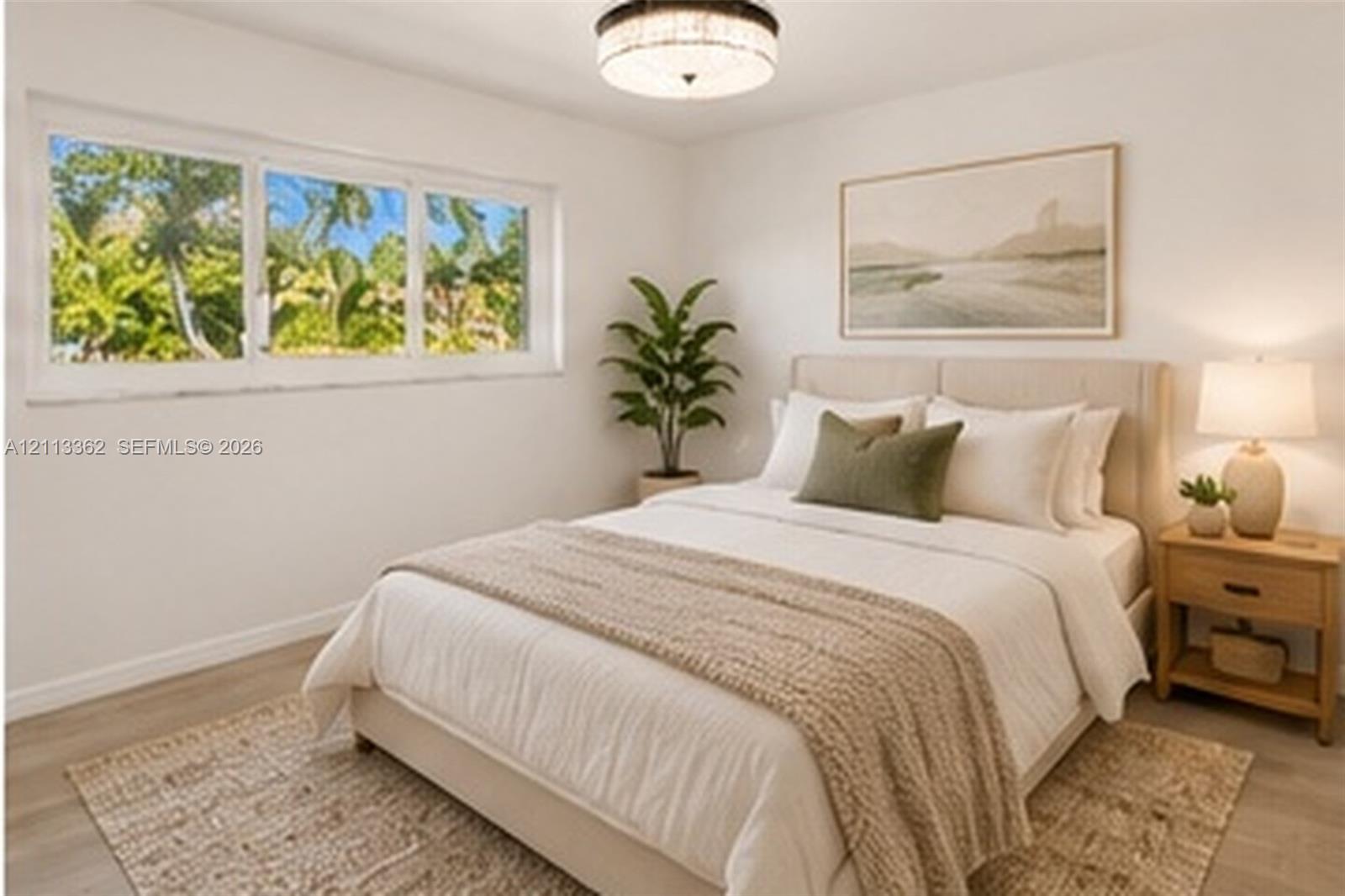 Bright interior featuring wood-finish flooring, a multi-pane horizontal window, and a circular flush-mount ceiling light fixture with a metallic frame