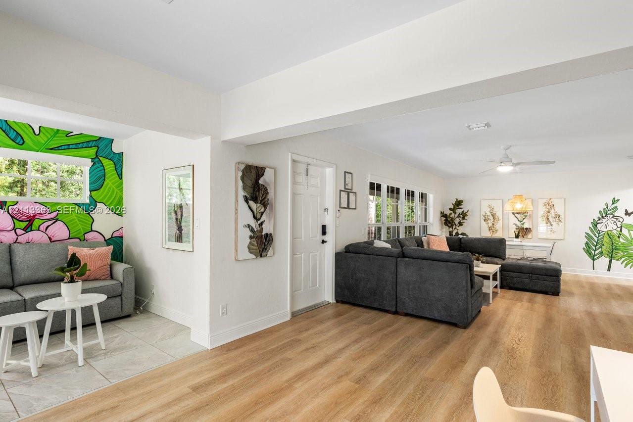Open-concept interior featuring light wood-finish flooring, recessed lighting, and multi-pane windows