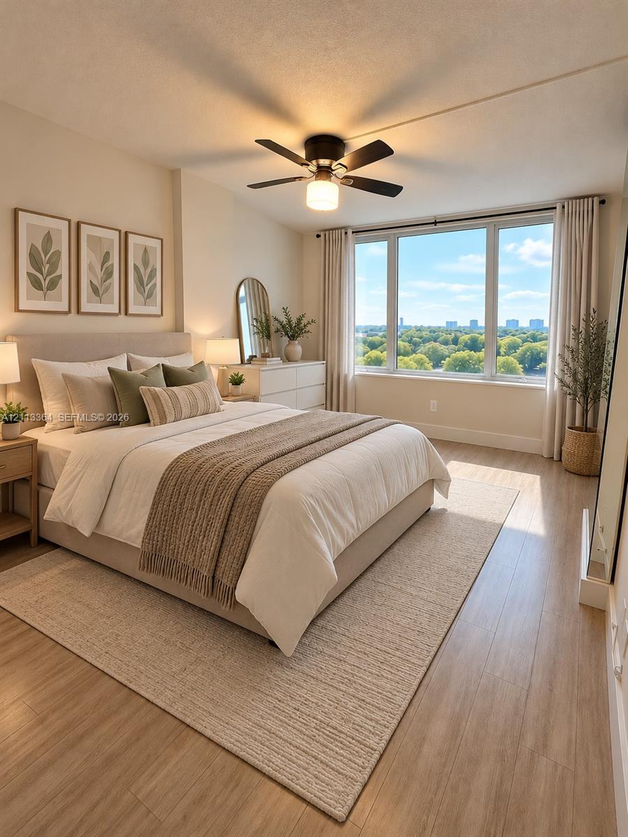 Large picture windows featuring natural light, wood-finish flooring, and a central ceiling fan with integrated lighting