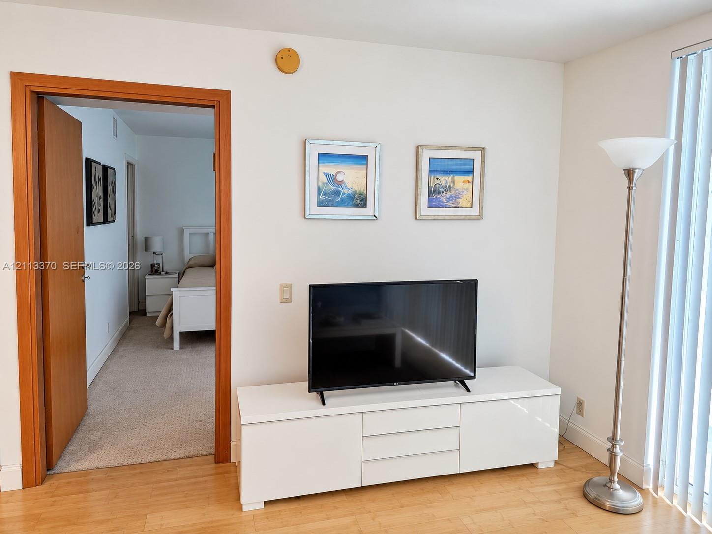 Wood-finish flooring, smooth interior walls, and vertical window blinds