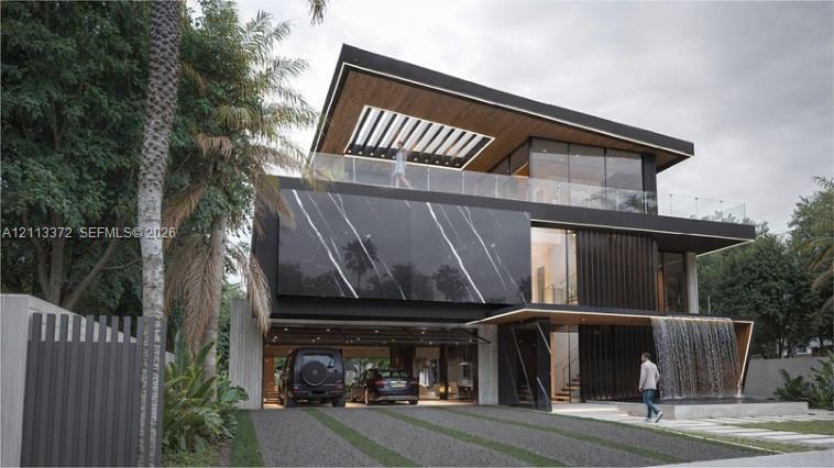 Contemporary architectural exterior featuring a stone-clad facade with distinctive veining, a covered carport, an integrated water feature, and a glass-railed upper-level terrace with a wood-finished soffit