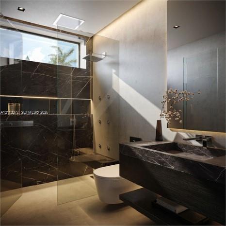 Walk-in shower with stone-clad walls, glass partition, and wall-mounted shower heads