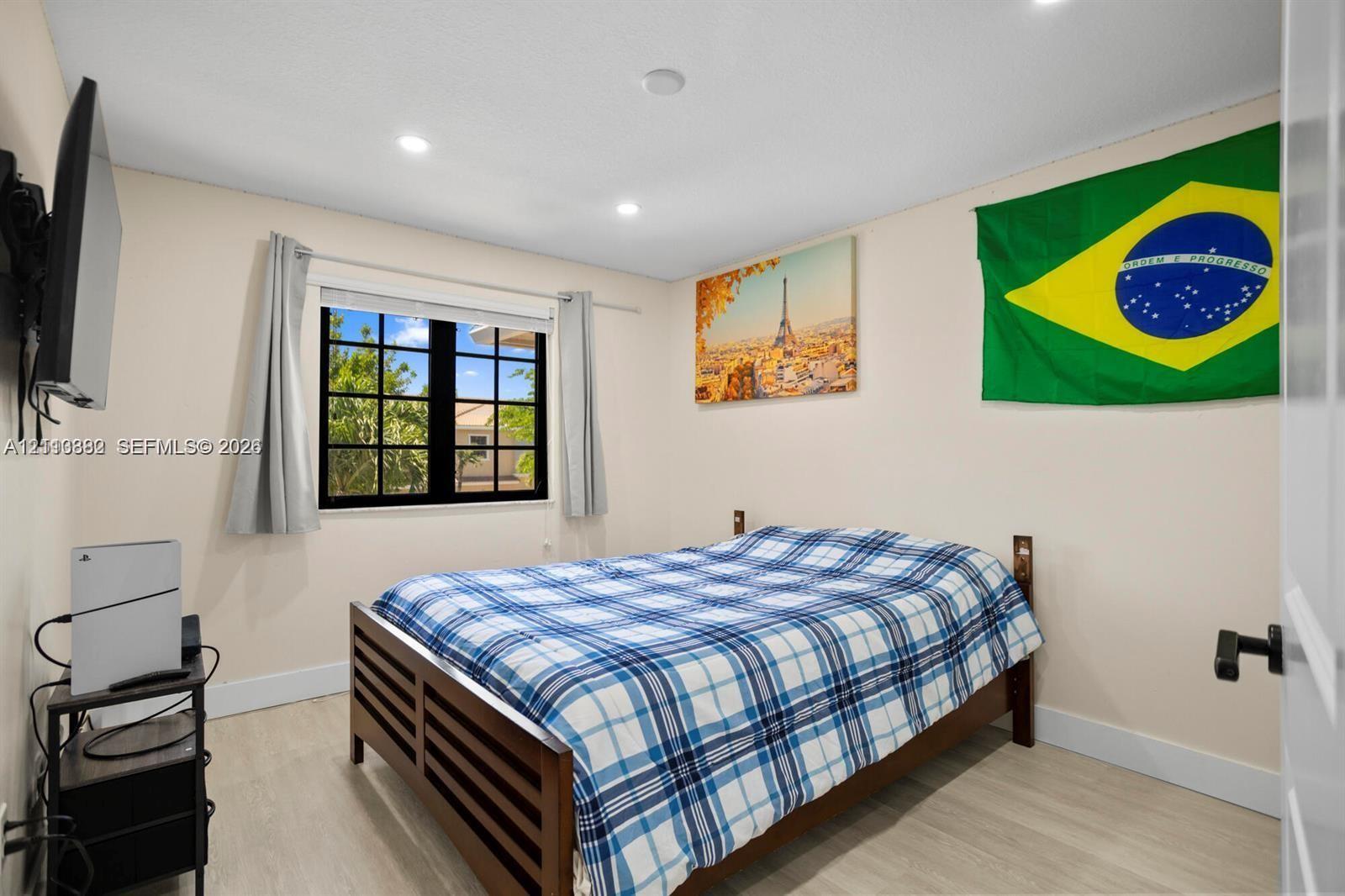 Wood-finish flooring, recessed lighting, and multi-pane window with black frame