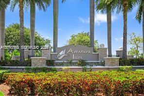 Community entrance signage featuring masonry pillar accents, decorative landscaping, and mature palm trees Community entrance signage featuring masonry pillar accents, decorative landscaping, and mature palm trees