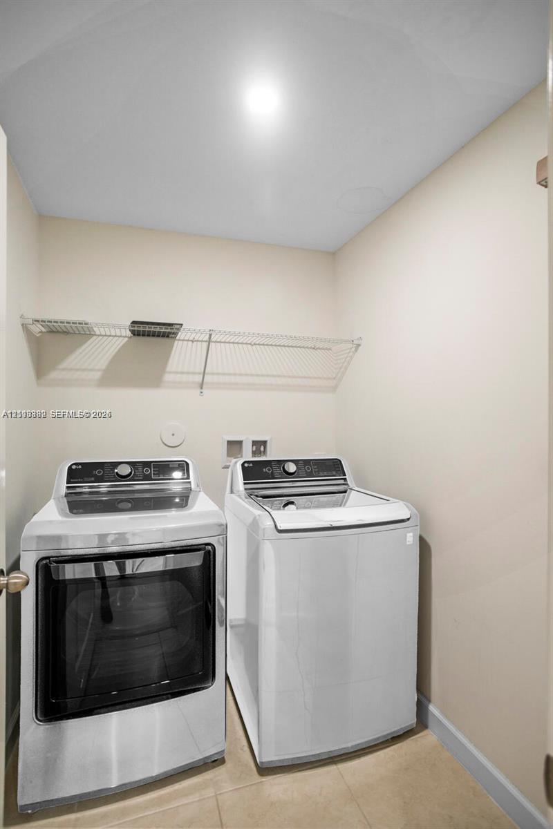 Laundry closet featuring tile flooring and wall-mounted wire shelving