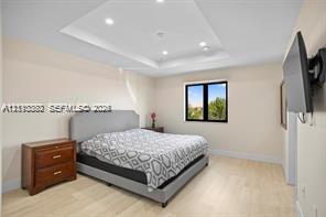Tray ceiling featuring recessed lighting and light wood-finish flooring
