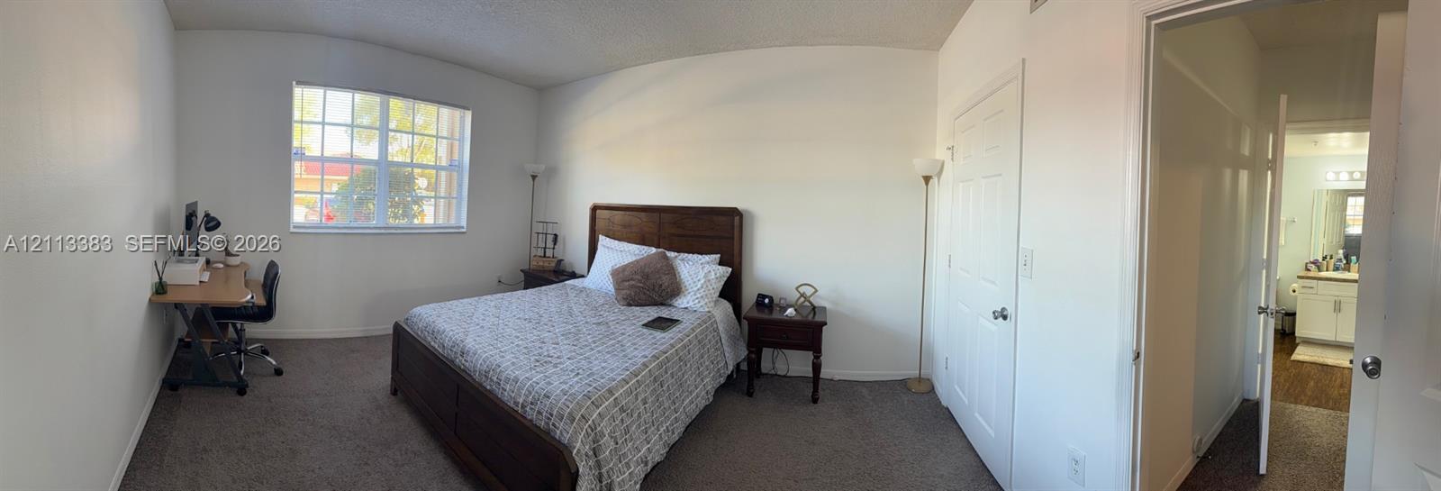 Room featuring neutral-toned carpeting, multi-pane window, and white interior doors