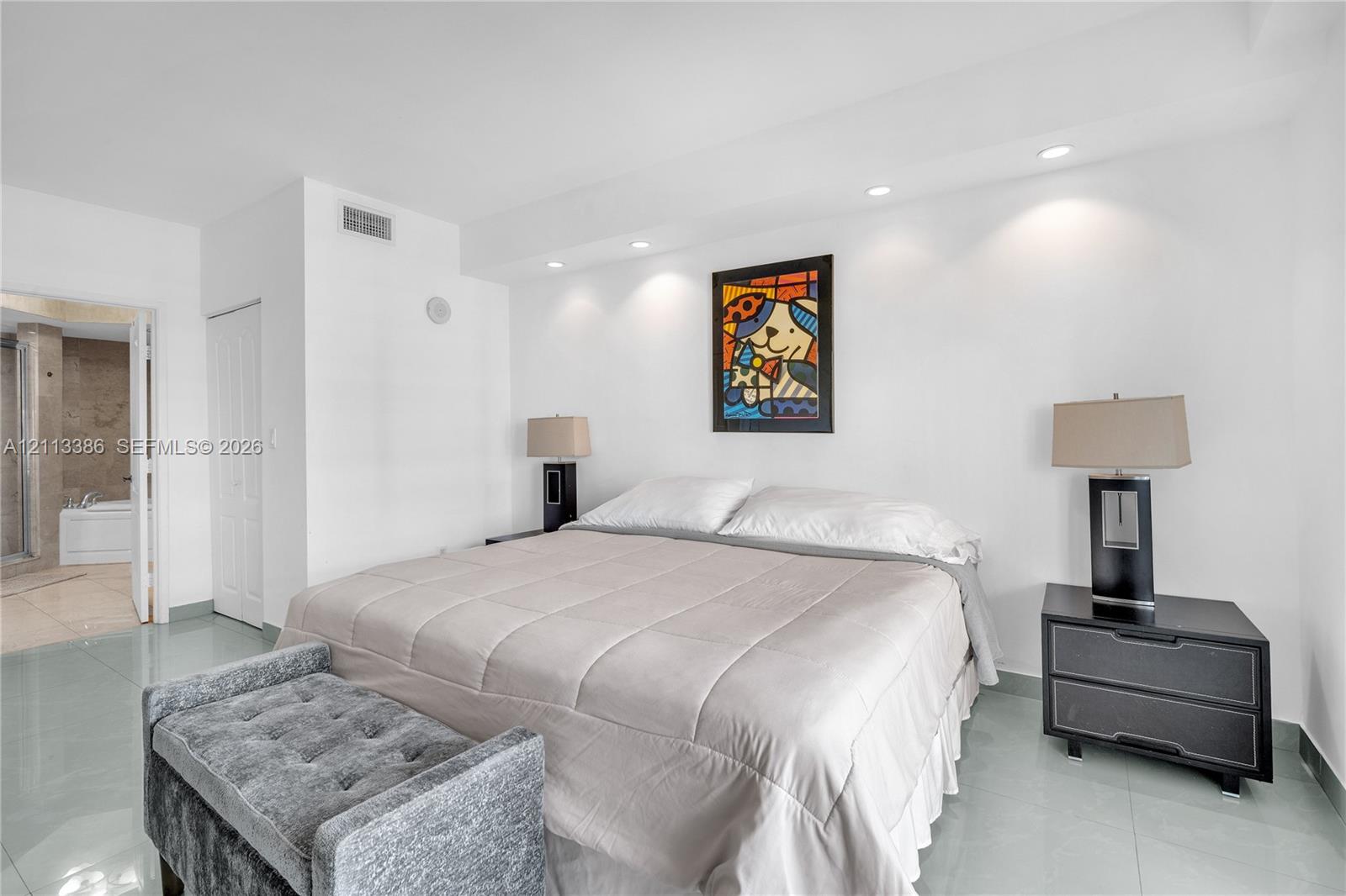 Spacious room featuring polished tile flooring, recessed ceiling lighting, and a neutral color palette