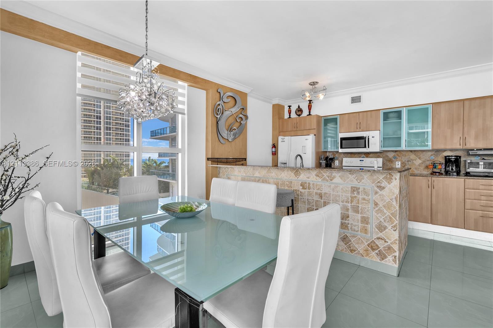 Kitchen featuring light-finish cabinetry, stone-tiled backsplash, and a stone-clad breakfast bar Kitchen featuring light-finish cabinetry, stone-tiled backsplash, and a stone-clad breakfast bar